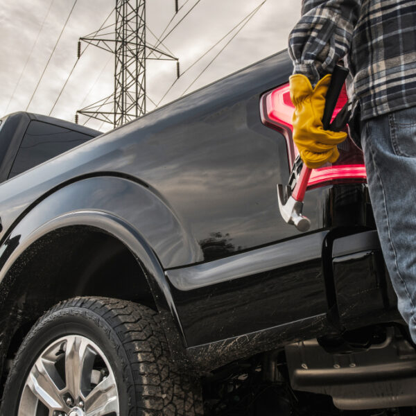 Contractor with Tools and His Truck. Closeup Photo. Construction Theme.